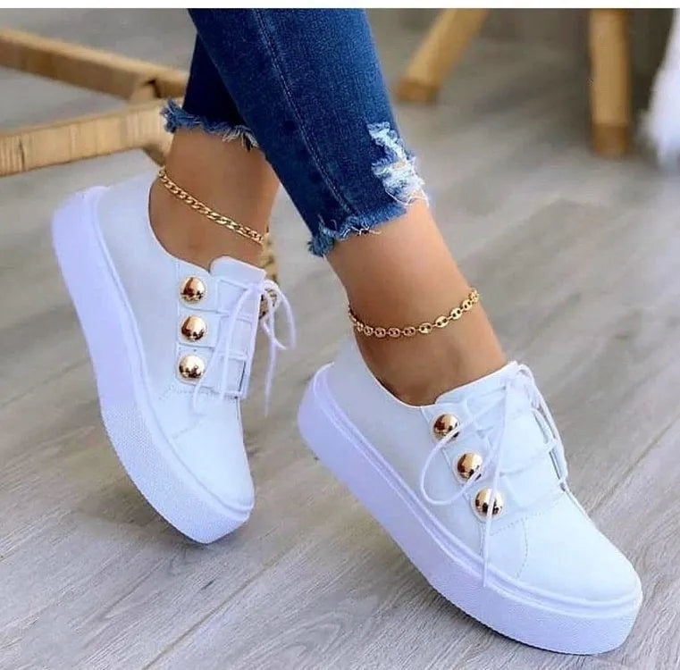 Women's white lace-up flats sneakers with silver rivet detailing and round toe design