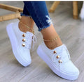 Women's white lace-up flats sneakers with silver rivet detailing and round toe design