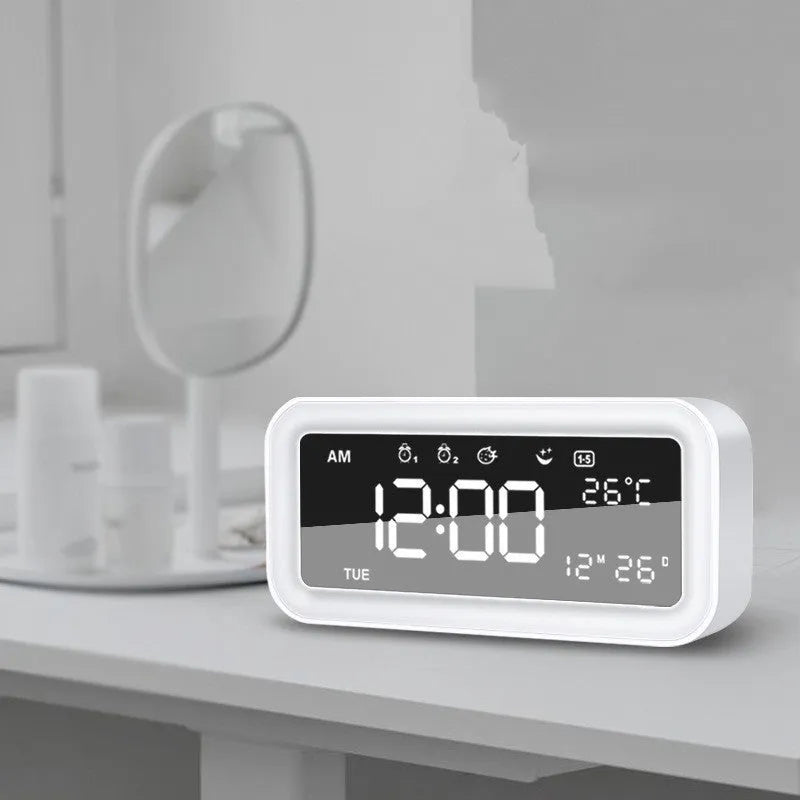 Blue rectangular LED digital alarm clock with multicoloured lighting and Bluetooth speaker on a bedside table.