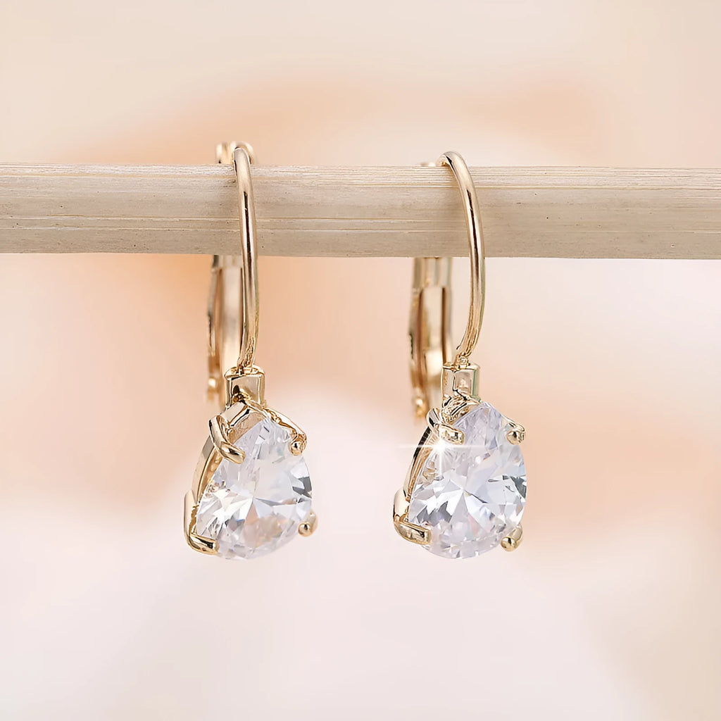 Drop-shaped women's fashion earrings in gold or platinum finish with an inlaid gem