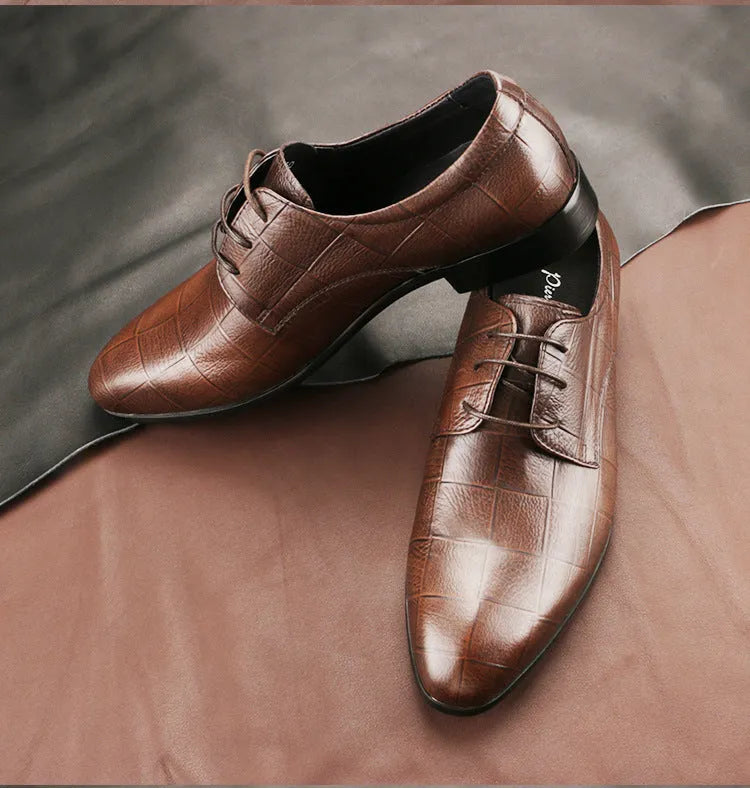 Men's black cow leather derby shoes with a pointed toe and rubber sole on a grey background.