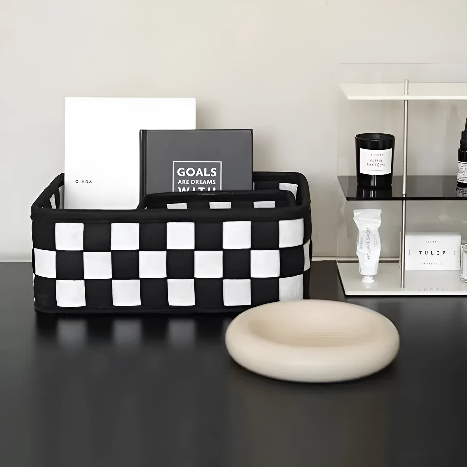 Checkerboard pattern black and white felt storage basket with folded sides.
