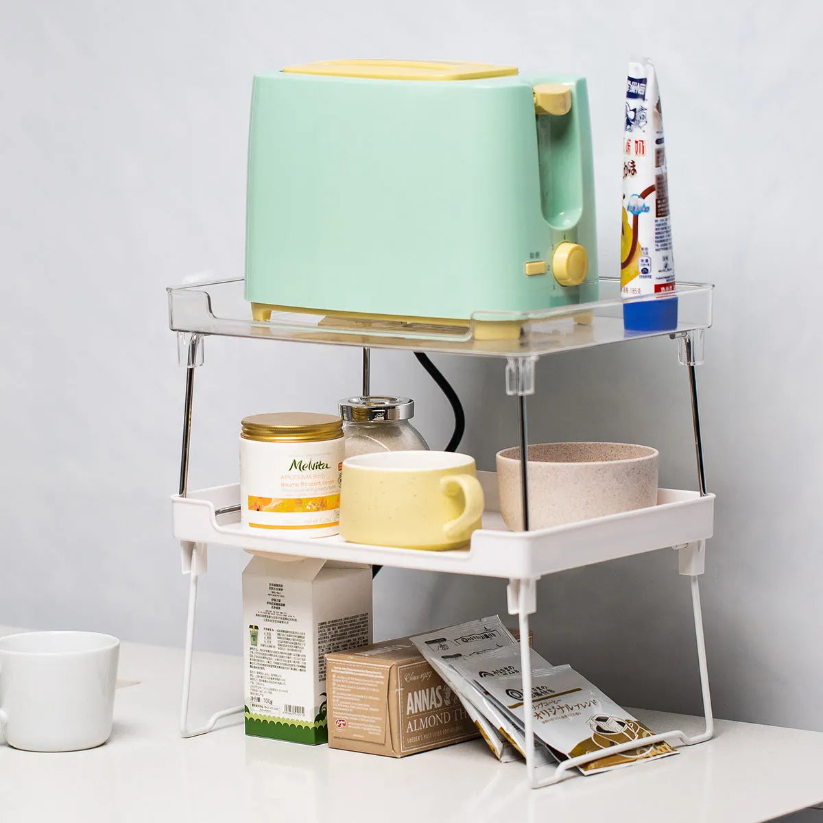 Plastic kitchen storage rack in transparent or white for cabinet and countertop organisation