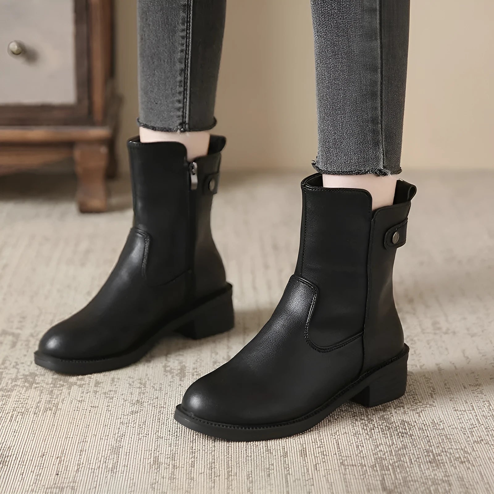Black women's ankle boots with a side zip, round toe, and low rubber sole.