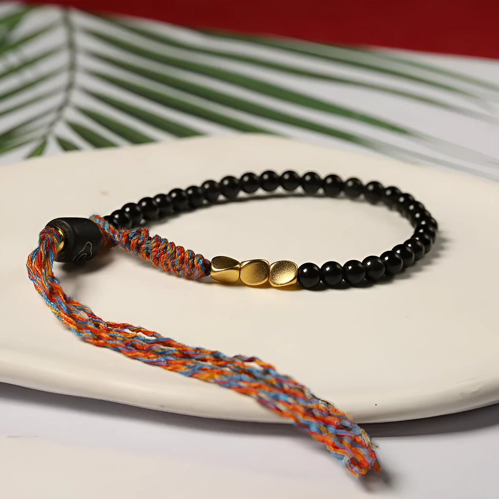 Hand-woven obsidian stone bracelet on a wrist, showing its dark colour and 4mm width.