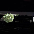 Solid jasmine car perfume diffuser clipped on a car air vent in off white or fresh green.