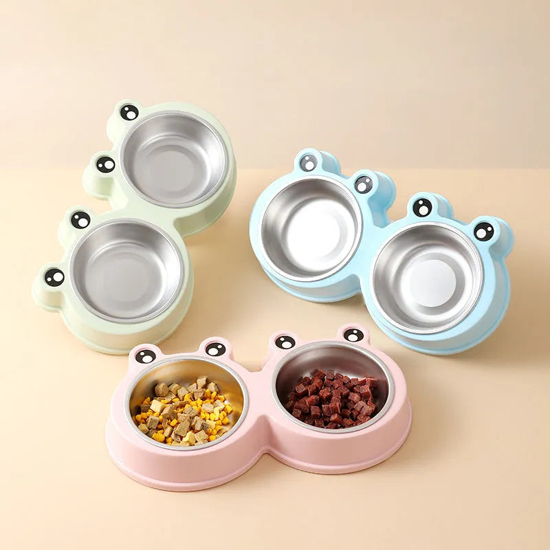 Blue stainless steel double pet bowl with frog design, showing separate food and water compartments on a non-slip base.