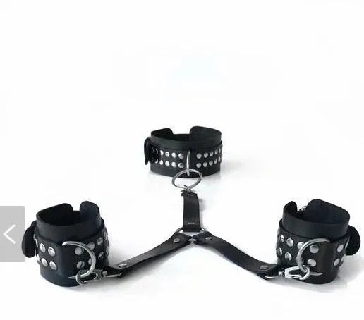 Black leather backhand neckcuffs on a surface, ready for adult restraint use