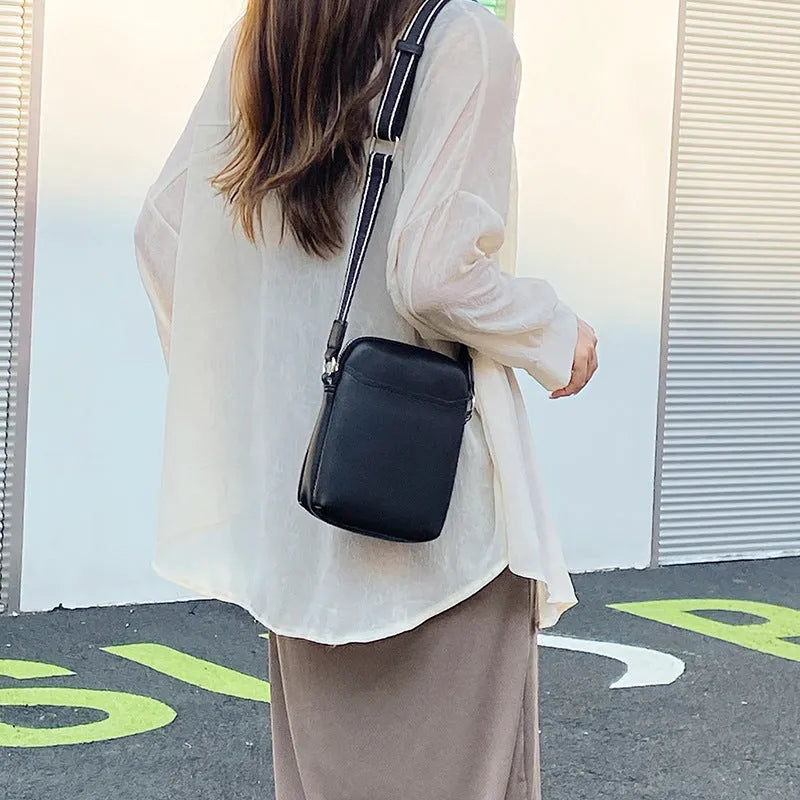 Women's solid colour PU crossbody shoulder bag showing compact dimensions and adjustable strap