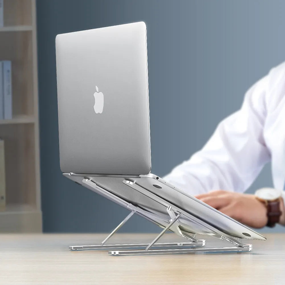 Aluminium foldable laptop stand in silver colour set to medium height with a laptop on top.