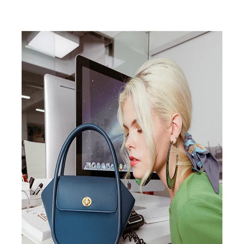 Wing-shaped women's leather handbag with latch closure and cross-body strap in available colours.