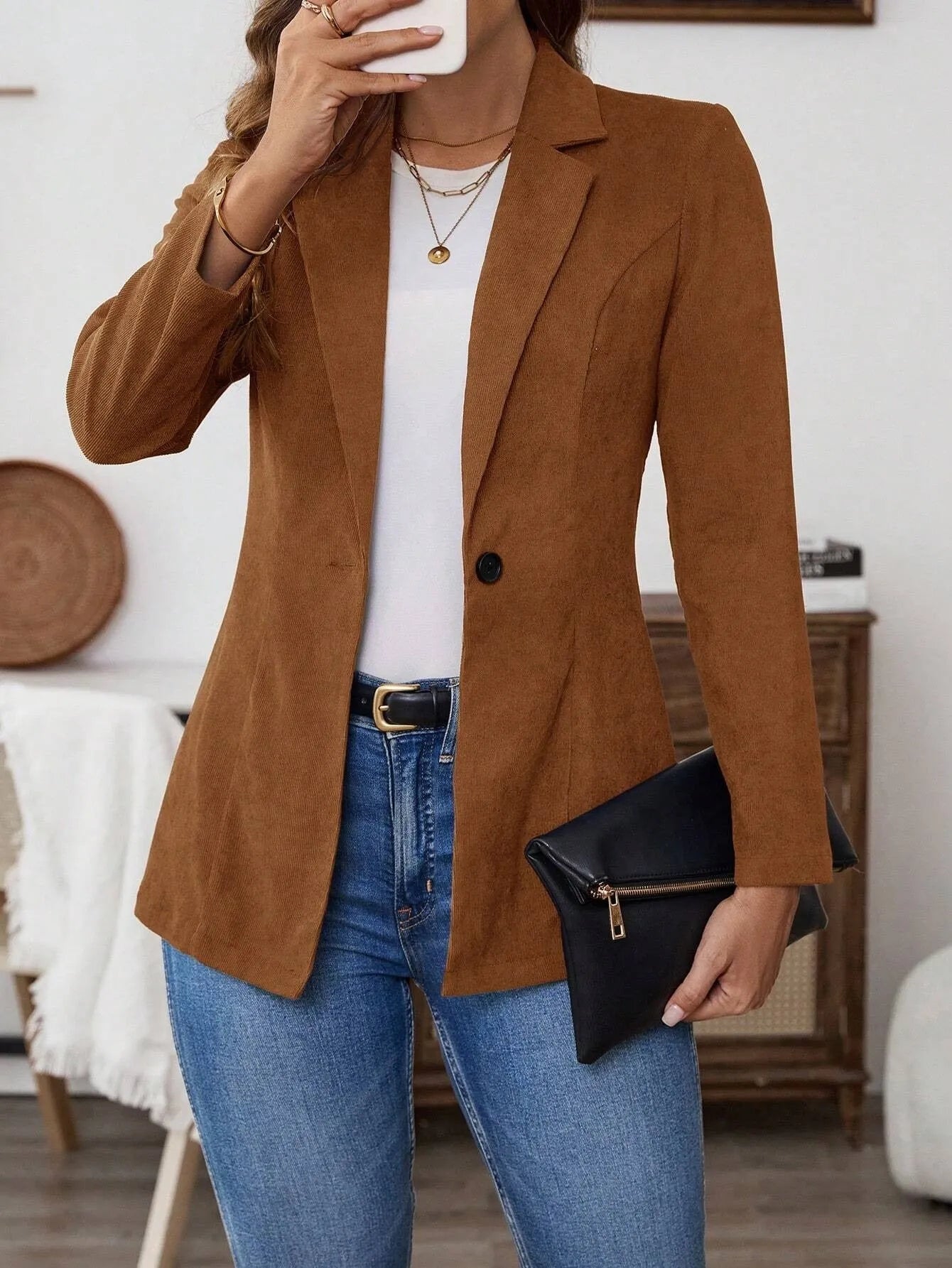 Brown single-breasted leisure blazer with lapel collar and long sleeves on a hanger.