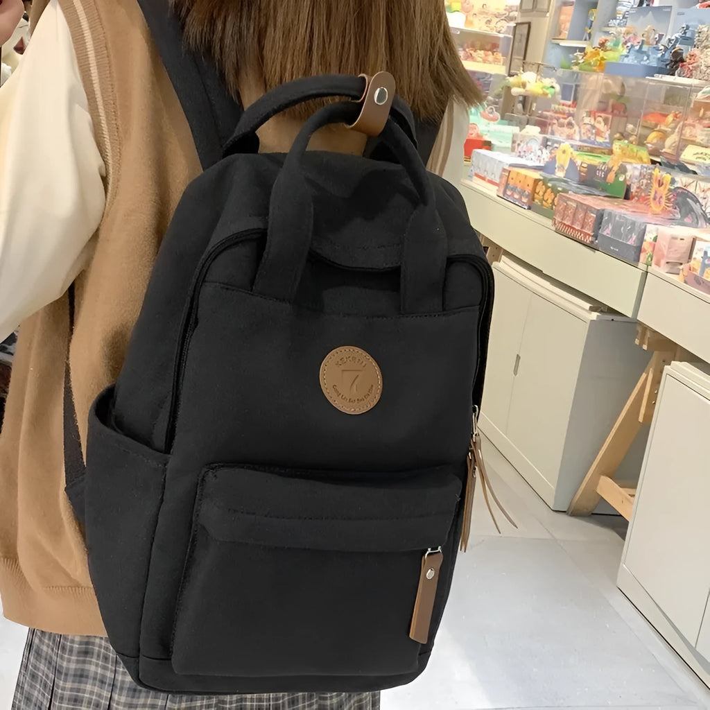 Black Oxford cloth fashion backpack with curved shoulder straps and retro sewing thread detailing
