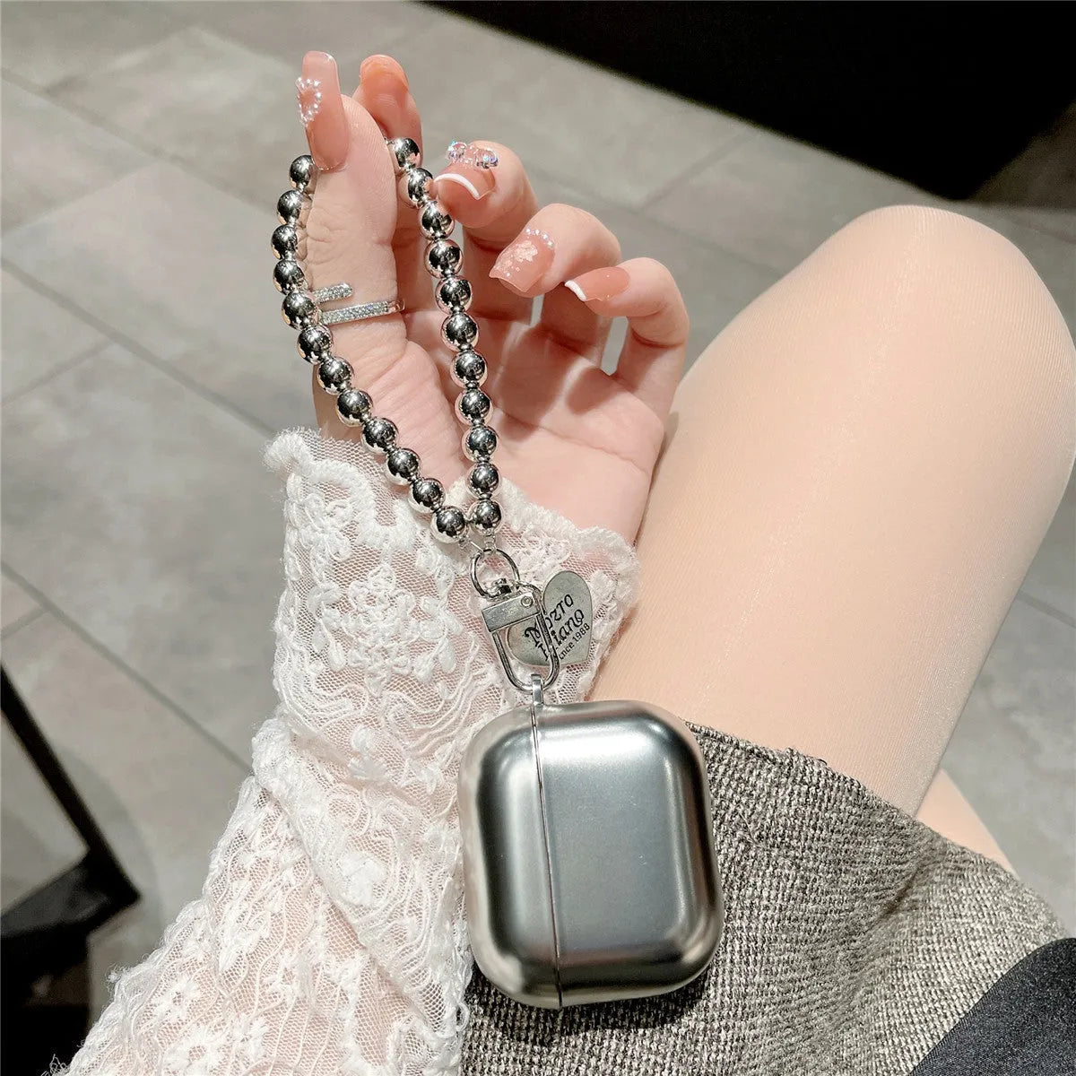 Matte plating protective case for Apple AirPods with an integrated carrying strap.