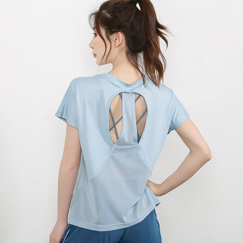 Women's short sleeve polyester sports t-shirt in pink, shown on a hanger.