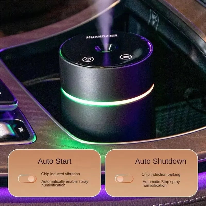 Black aluminium car humidifier diffuser with night light on a desk next to USB cable