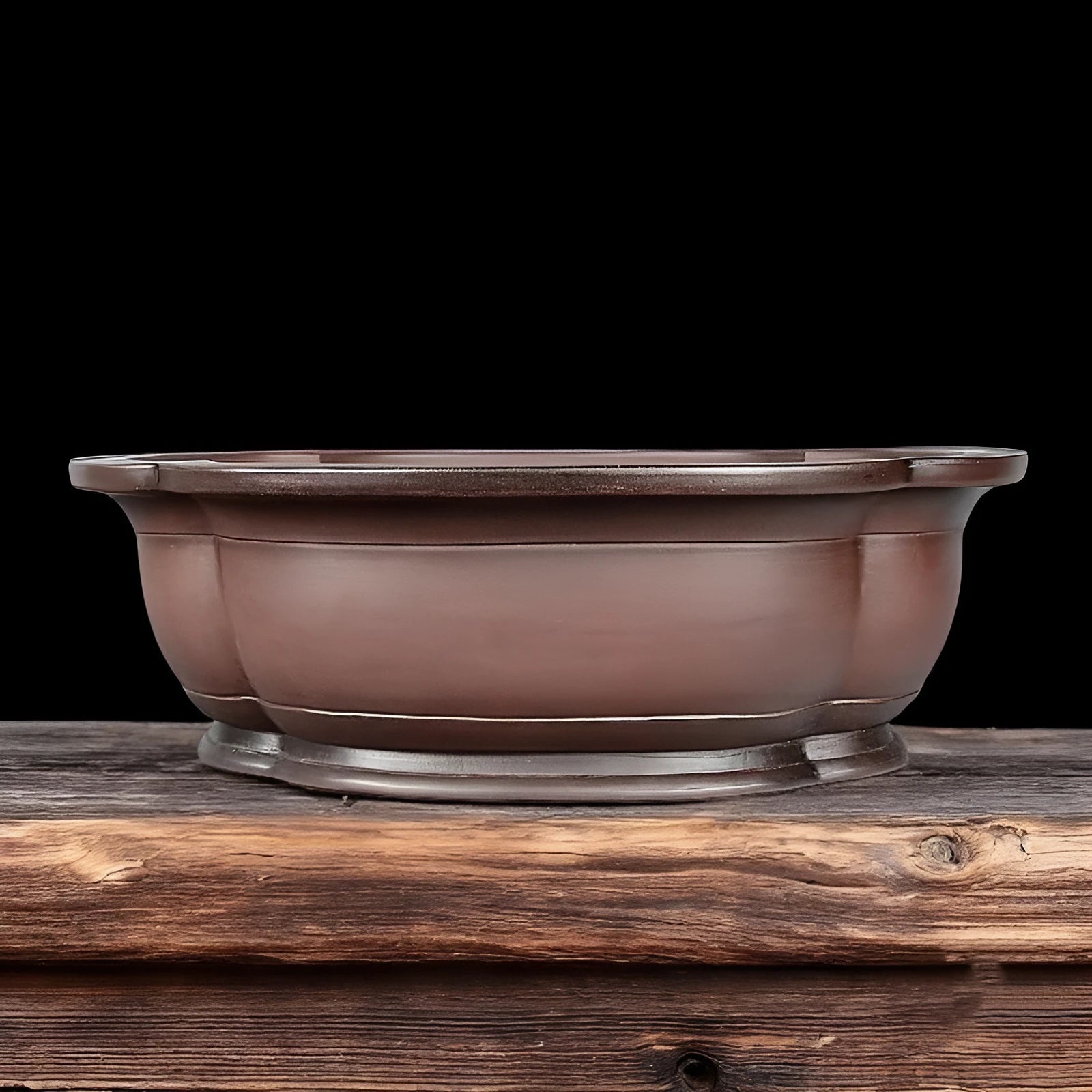 Handmade antique crabapple shaped purple clay flower pot on a wooden floor.