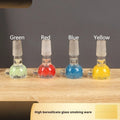 Transparent coloured glass tobacco pipe, trumpet shape, 7cm tall, on a plain background.