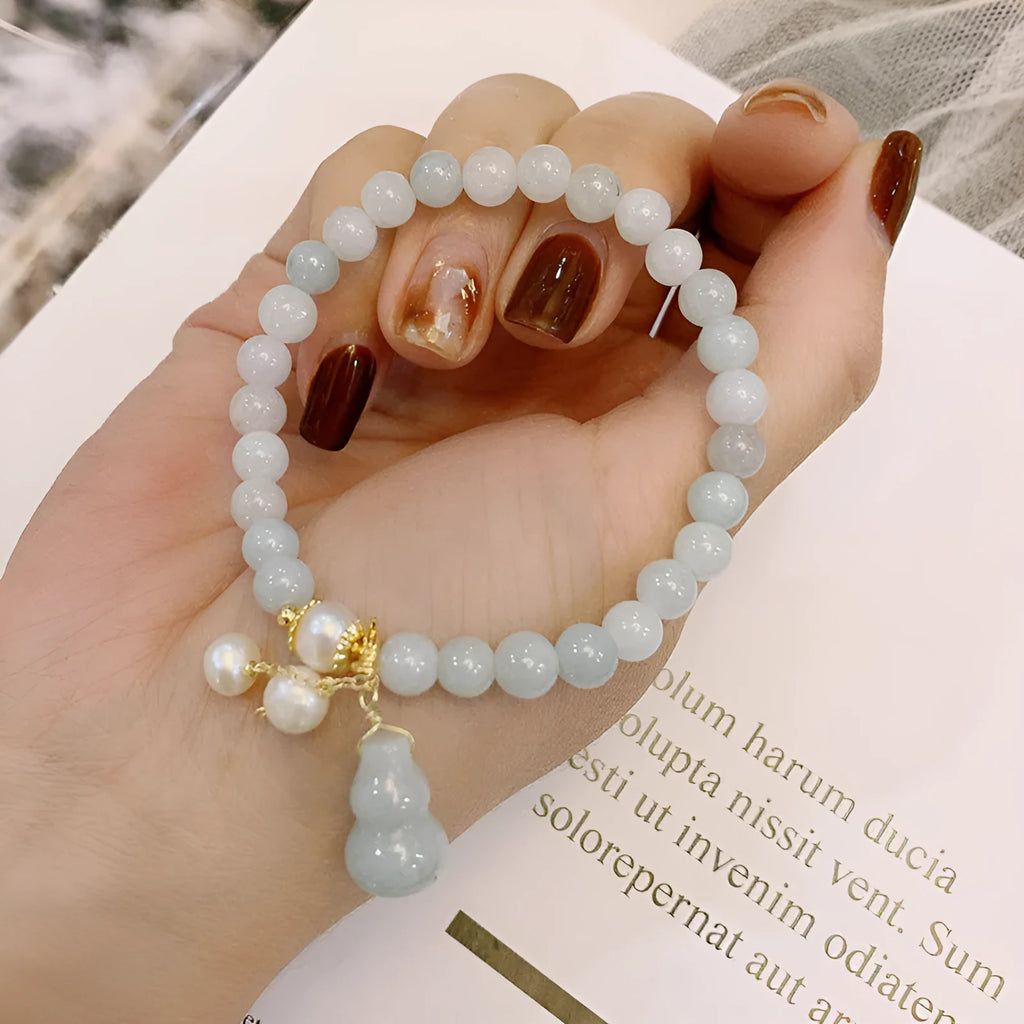 Emerald green jade bracelet with a raised gourd design in a Chinese style.