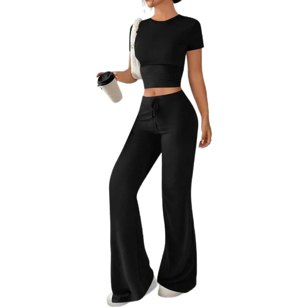 Women's black high waist trousers and short sleeve t-shirt co-ord set laid flat.