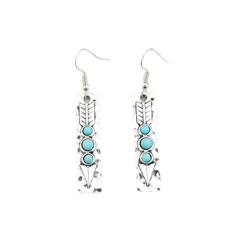 Long silver geometric earrings with a blue turquoise stone detail on a white background.