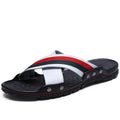 Men's white cowhide leather flip-flops with a non-slip PU sole, shown on a beach background