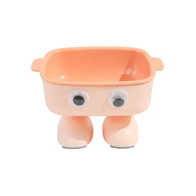 Green cartoon robot-shaped elevated cat bowl with tilted design and non-slip base on a table.