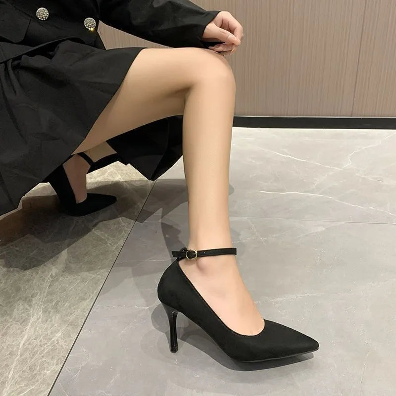 Black and creamy white women's stiletto heel pumps with a skull pattern and ankle buckle.