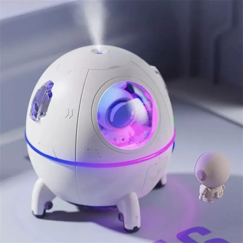 Purple astronaut-shaped USB desktop humidifier with colourful LED light on wooden desk