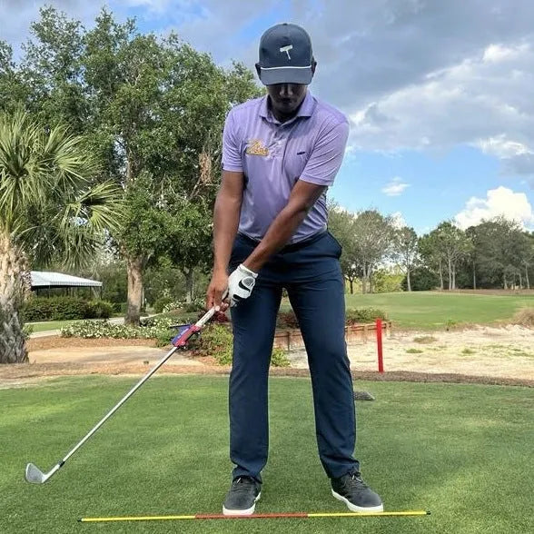 Plastic golf swing plane training simulator on practice surface