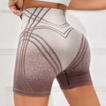 Women's high waisted gradient fitness shorts in black, shown for yoga and running.