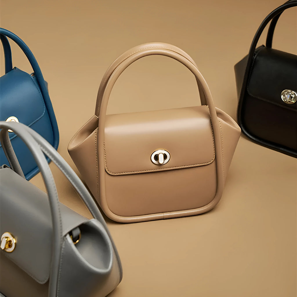 Wing-shaped women's leather handbag with latch closure and cross-body strap in available colours.