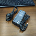 Black 65W USB-C laptop power adapter with UK plug and international travel adapters