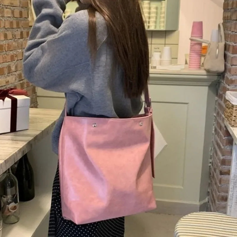 Pink corduroy one-shoulder bag with a single strap, shown next to a brown colour option.