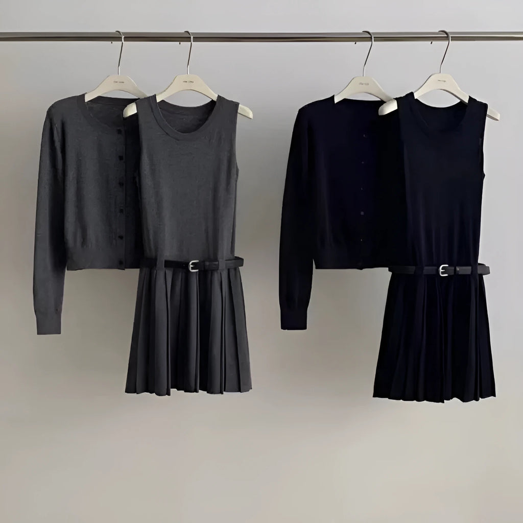 Women's black knitted two-piece set with long-sleeve cardigan, pleated vest skirt, 3D pattern, and a belt.