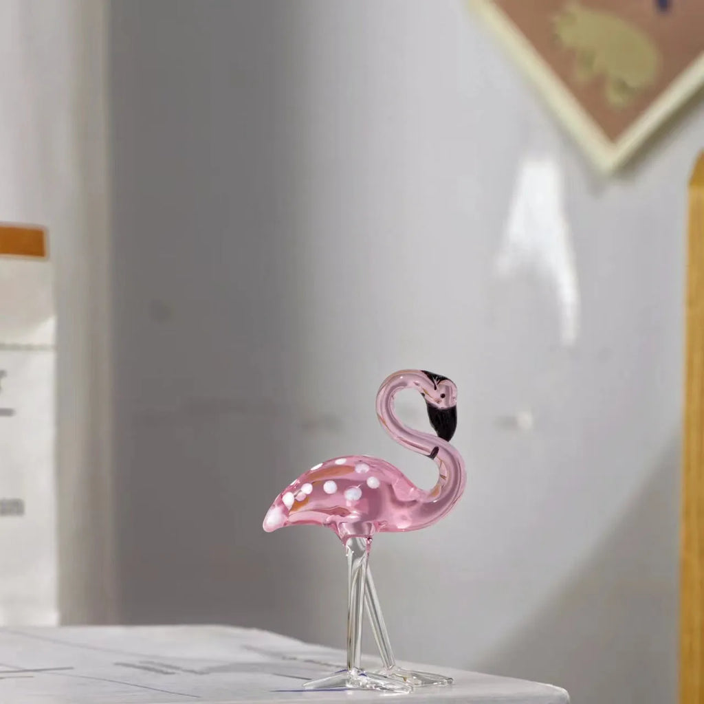 Pink crystal flamingo decorative ornament on a table, modern minimalist style.