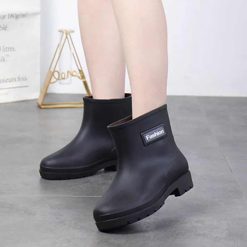 Women's mid-calf rain boots in black, PVC upper, shown with a low heel.