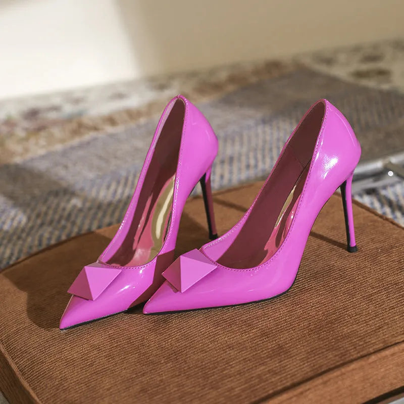 Pink patent leather women's stiletto heels with pointed toes and buckle fastening