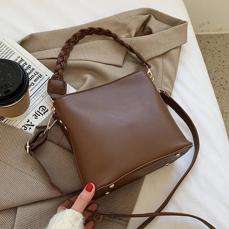 Retro unisex brown PU bucket bag with woven detail, shown with crossbody strap.