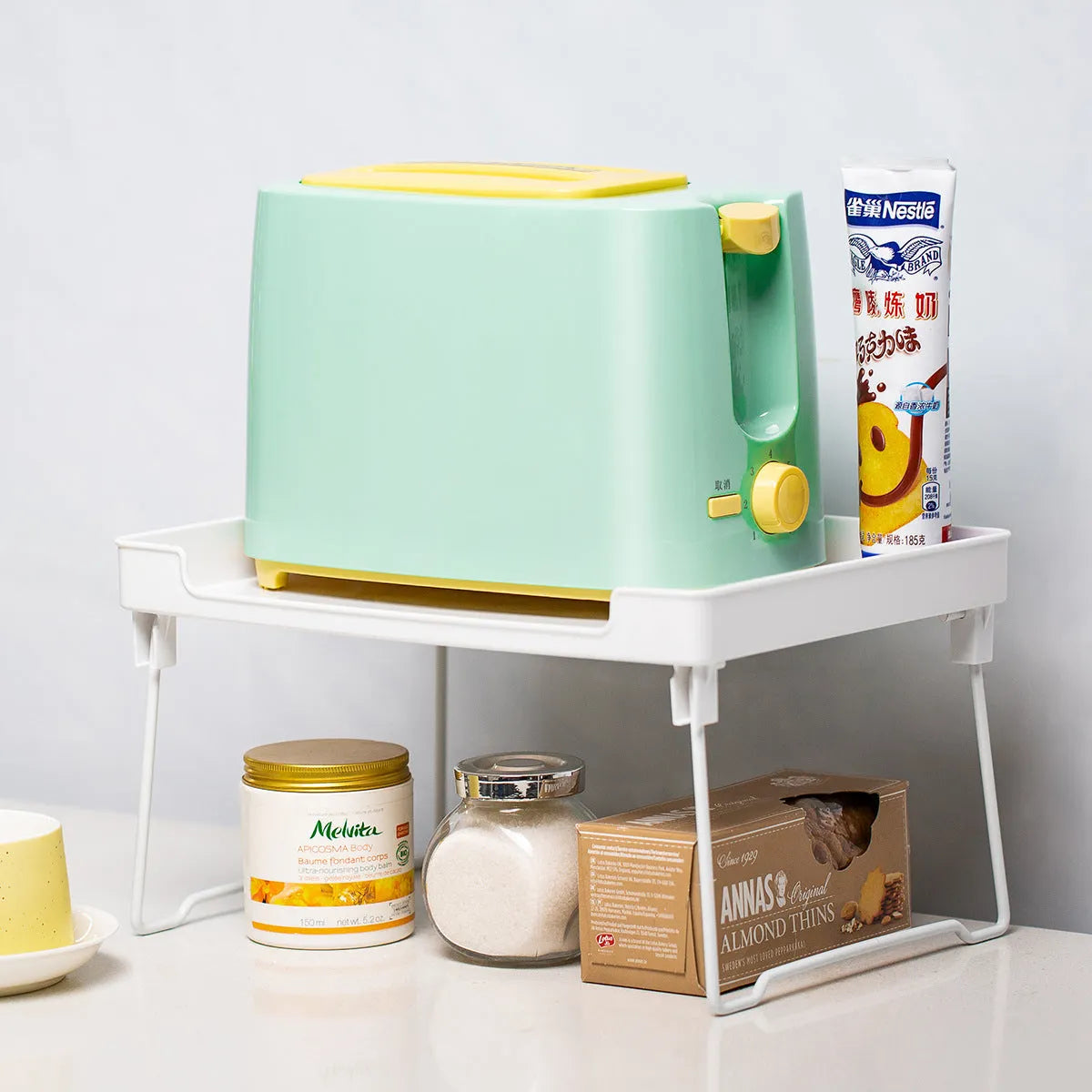 Plastic kitchen storage rack in transparent or white for cabinet and countertop organisation