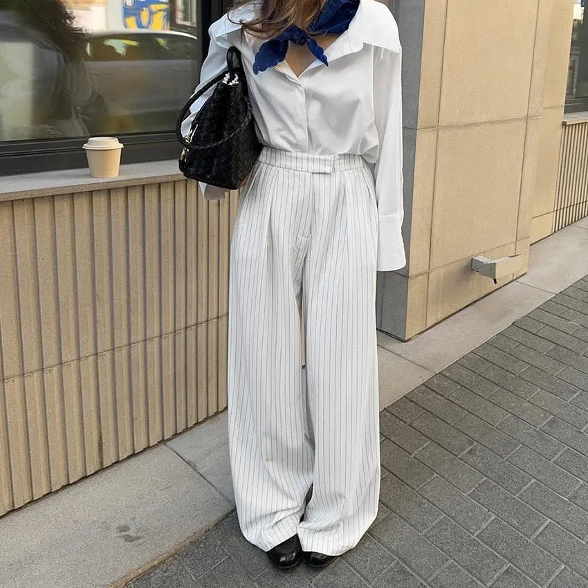 White striped wide-leg trousers with a front zip closure on a model.