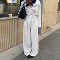 White striped wide-leg trousers with a front zip closure on a model.
