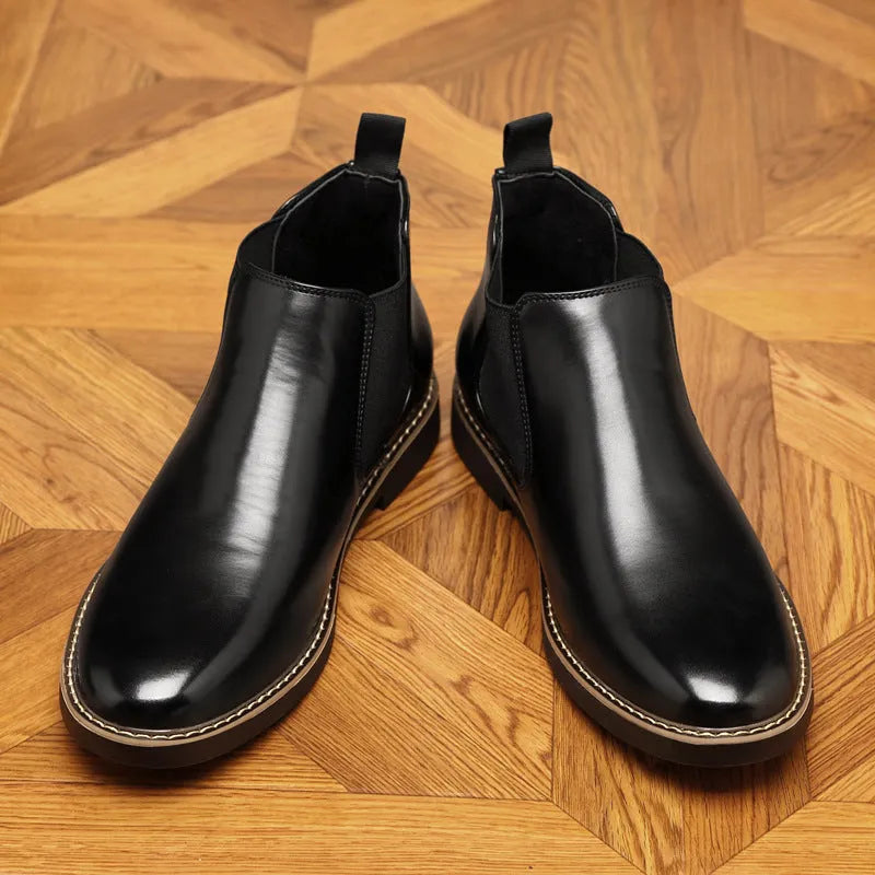 A pair of black formal pointed-toe leather boots with a square heel and rubber sole.