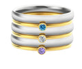 Geometric titanium steel ring with engraved design in December birthstone colour on a finger.