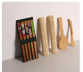 White plastic sushi tool set with moulds for rolls and Nigiri and a rice paddle on a light background