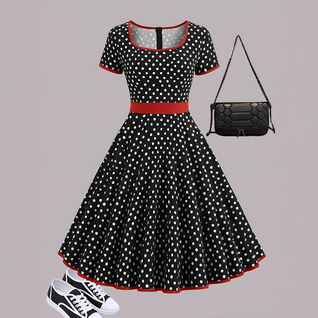 Square collar short sleeve polka dot dress with pleats and a zip on a mid-length skirt.