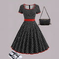 Square collar short sleeve polka dot dress with pleats and a zip on a mid-length skirt.