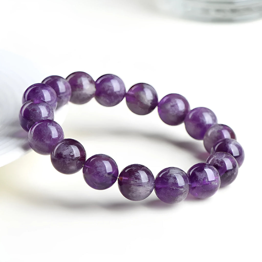Natural Feather Amethyst Ruyi crystal bracelet with scattered geometry beads on a wrist.