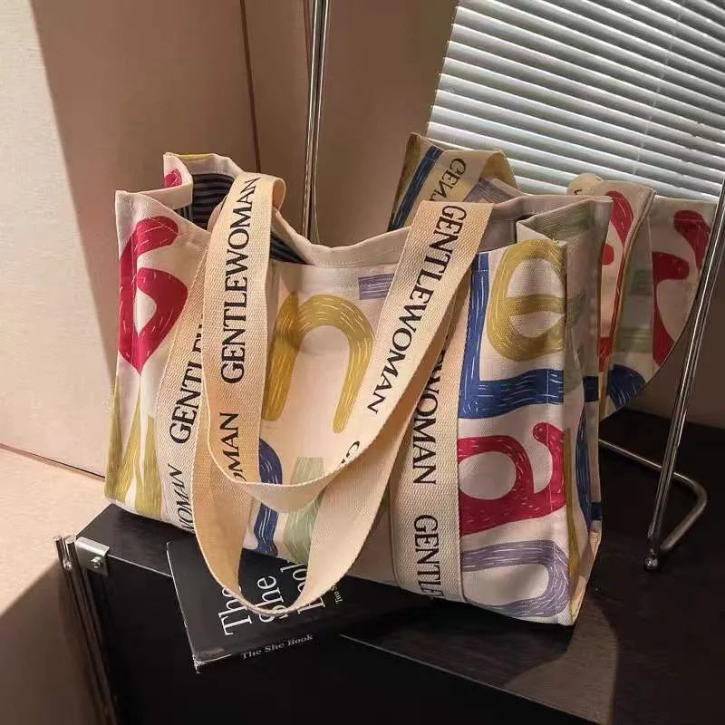 Large canvas tote bag with printed design options including letters and patterns.