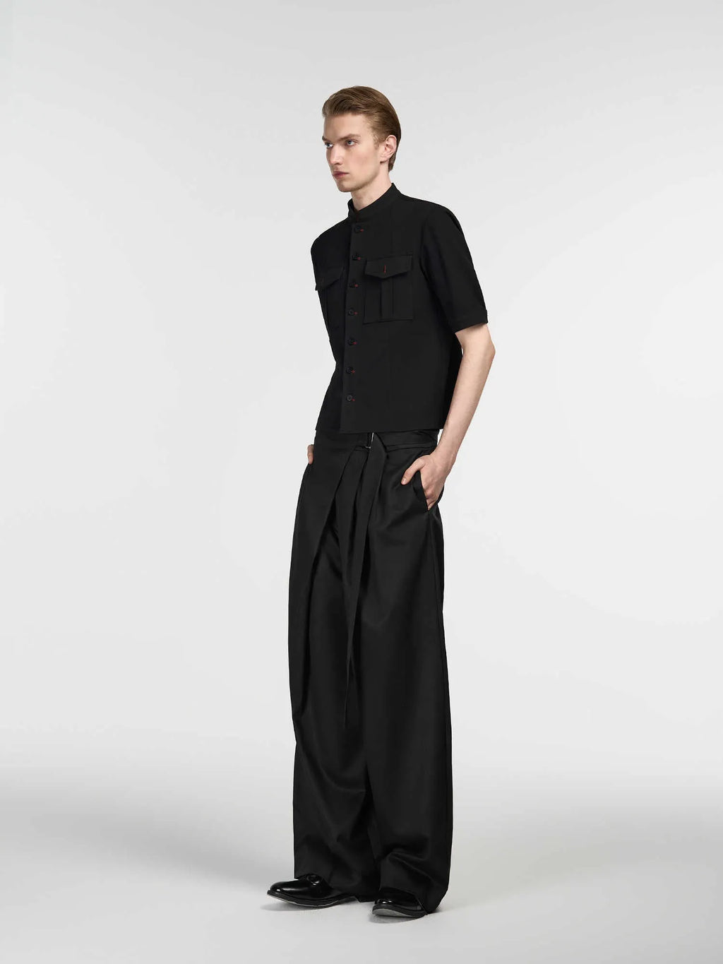 Black straight-leg women's trousers with a pleated front and adjustable waistband on a neutral background.